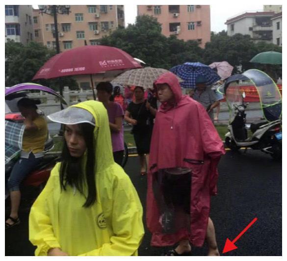 岳云鹏本人?穿大红雨衣大裤衩,脚踩拖鞋雨中接娃,随意又朴素